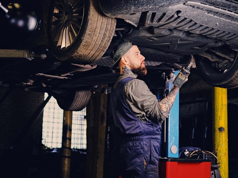 bearded-mechanic-working-with-the-cars-chassis-in-small.jpg